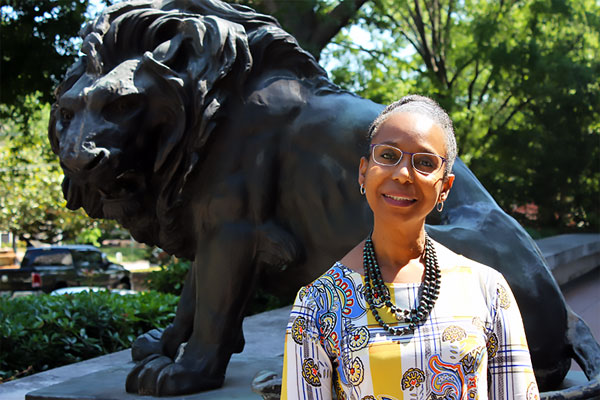 2019 Julie Klauber Award Winner - Brenda Boyd (standing in front of a lion statue)